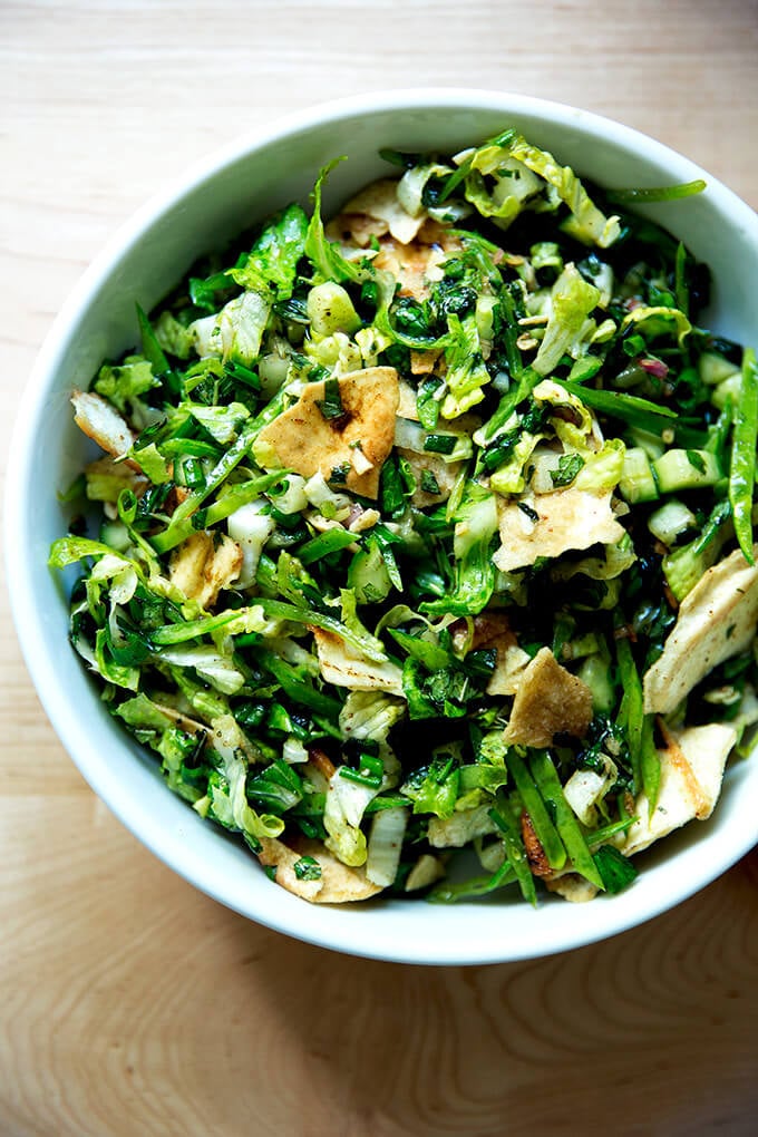 A finished bowl of a spring salad with crispy pita and fattoush dressing.