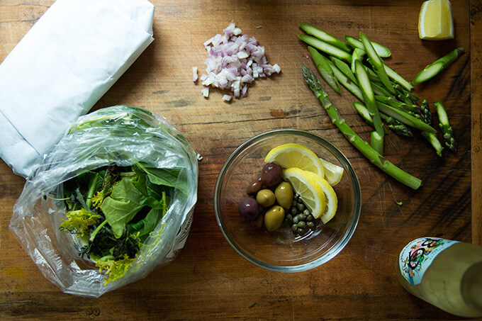 Ingredients for fish en papillote on a board.