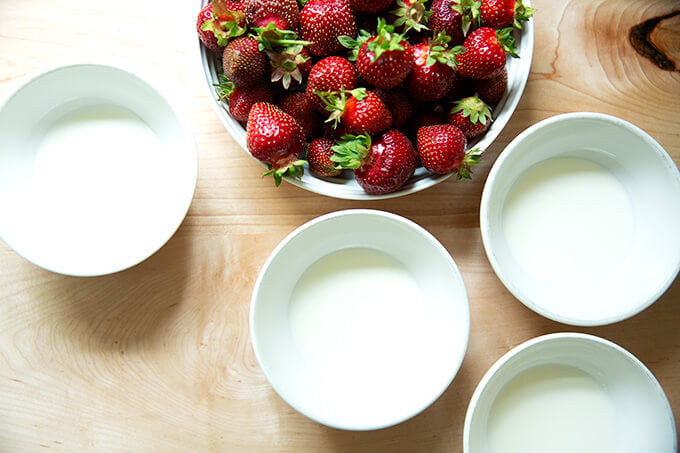 A bowl of strawberries + 4 bowls of cream.