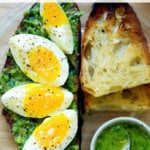 A slice of toast topped with herby green sauce and 7-minute eggs.