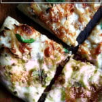 A caramelized onion and burrata pizza cut into quarters.