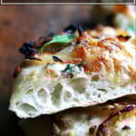 A sideview of caramelized onion and burrata pizza.