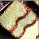 A lemon semolina cake on a board, sliced.
