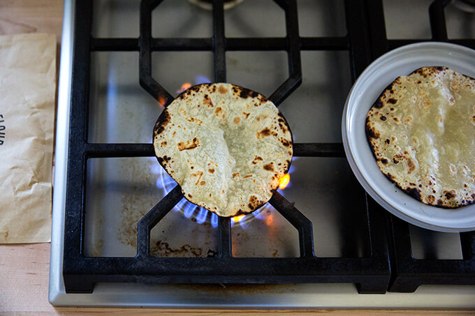 Charring the tortillas over a gas flame.