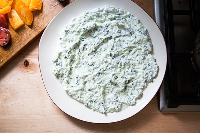 Cucumber-yogurt sauce smeared on a large platter.