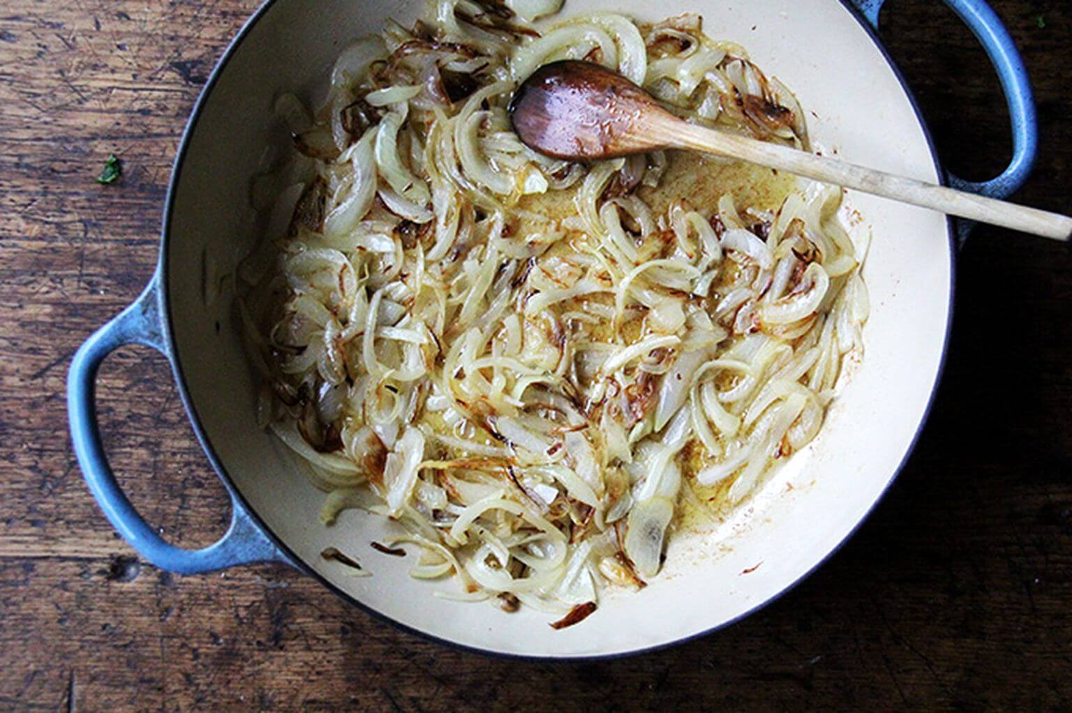 A large sauté pan filled with caramelized onions.