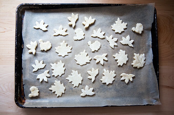 A sheet pan lined with parchment paper topped with unbaked pie cookies.