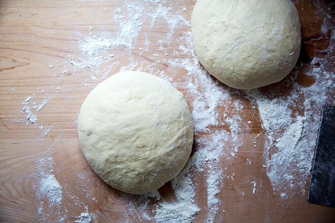 Brioche dough divided into two portions shaped into large rounds.