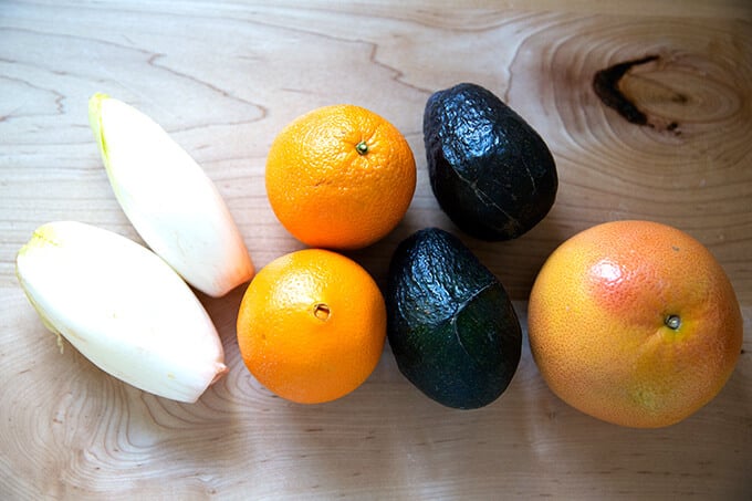 Endive, Cara Cara oranges, avocados, and grapefruit on a table.