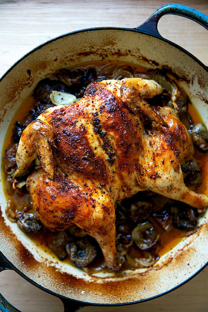 A platter of roast chicken with dates and artichoke hearts.