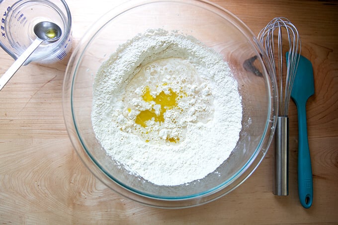Liquid ingredients added to dry ingredients on a counter.