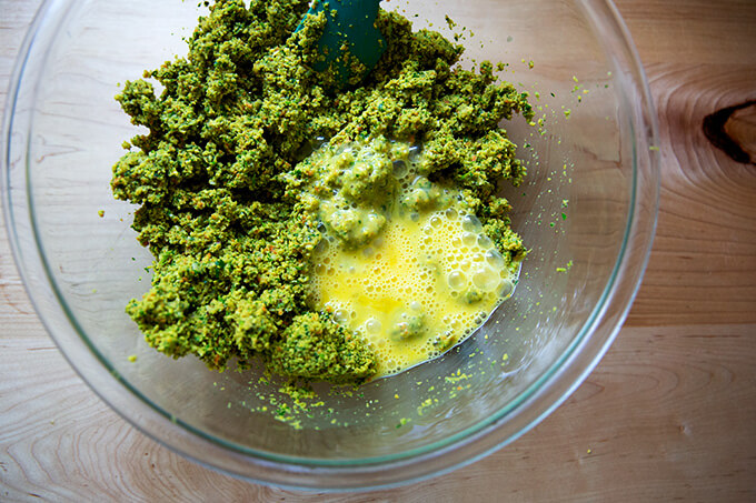 Adding two eggs to the falafel burger mix.