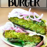 Halved falafel burger on a plate.