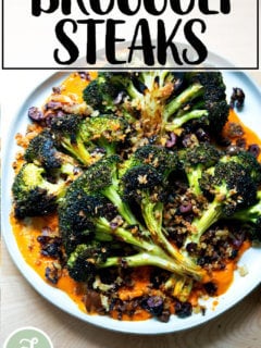 A plate of roasted broccoli steaks topped with olive bread crumbs.