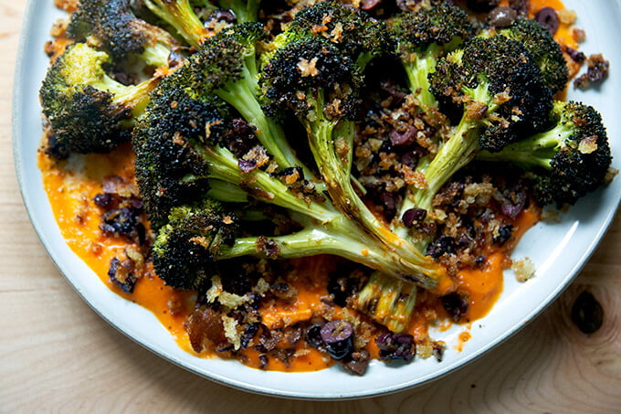 A plate of roasted broccoli steaks topped with olive bread crumbs.