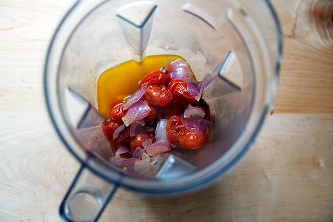 A blender filled with roasted broccoli and onions.