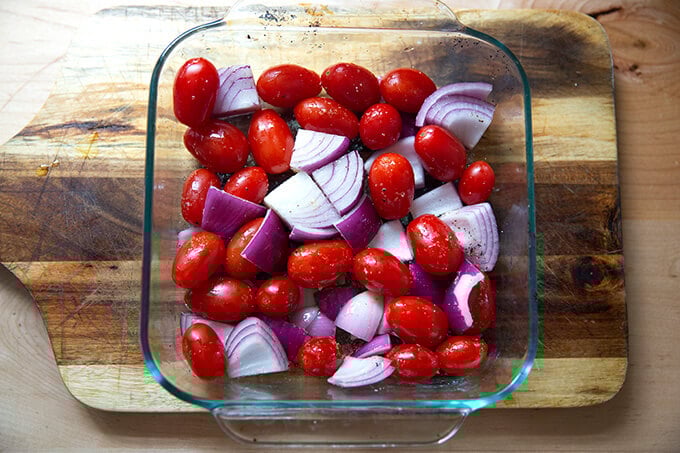 A pan of tomatoes and onions, tossed with olive oil and salt.