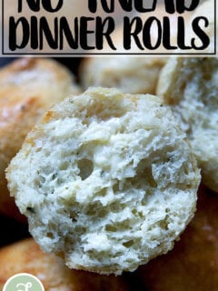 A halved and buttered thyme dinner roll.