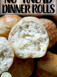 A halved and buttered thyme dinner roll.