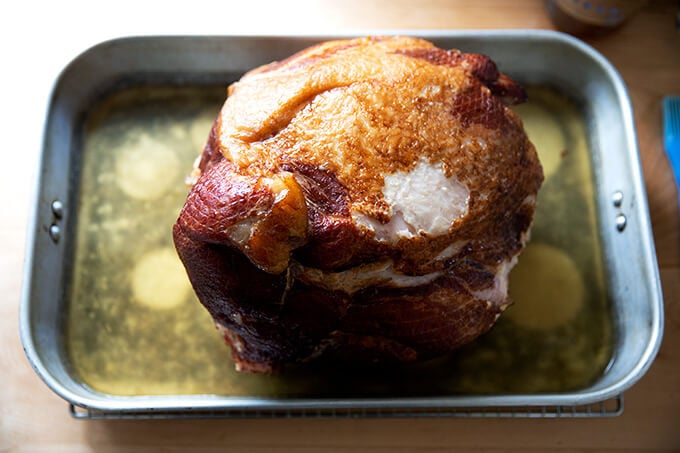 A whole bone in ham in a roasting pan after 1.75 hours in the oven.