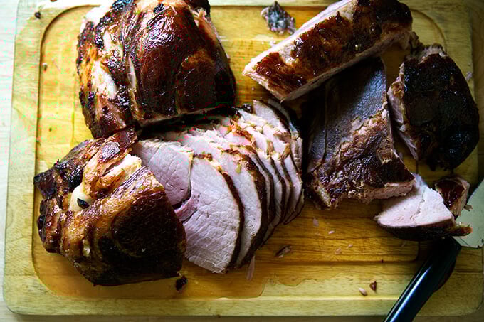 A carved ham on a board.