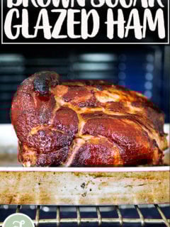 A brown sugar glazed ham in a roasting pan in the oven.