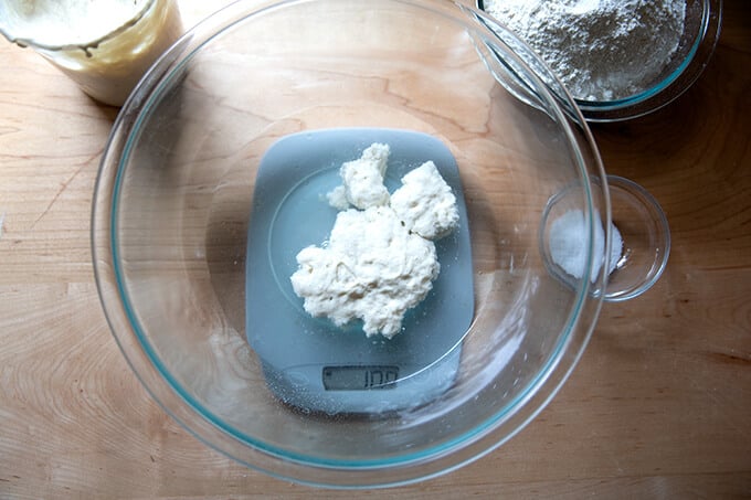 A bowl holding water and sourdough starter, unmixed.