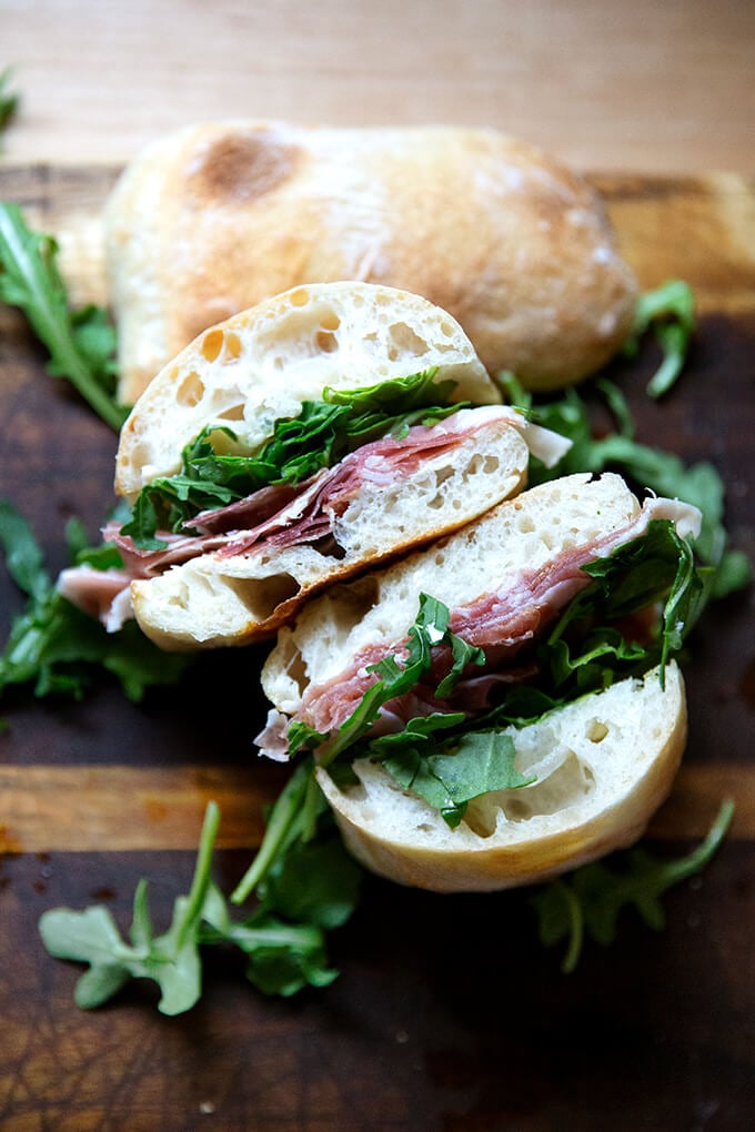 A halved prosciutto and arugula sandwich.