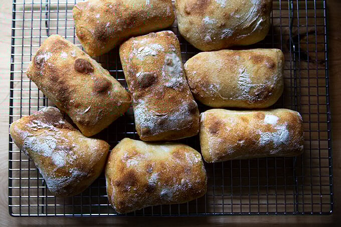 Just-baked sourdough ciabatta rolls on a cooling rack.