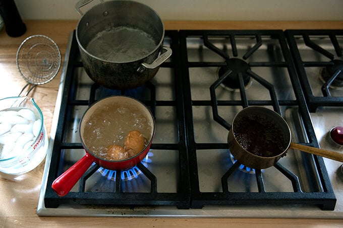 A stove top with three pots boiling away. 