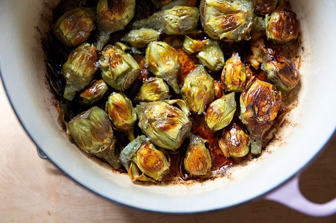 A large pot filled with just-cooked baby artichokes.