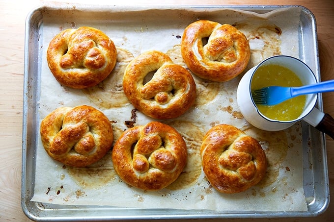 Just-baked soft pretzels on a sheet pan.