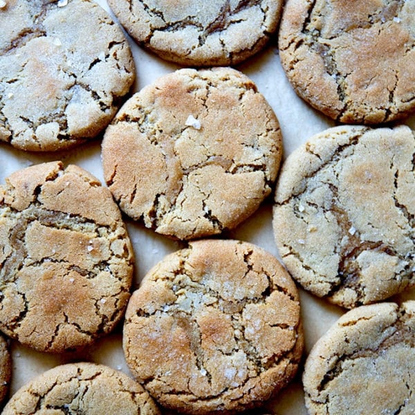 Just-baked peanut butter cookies all together on a sheet pan.