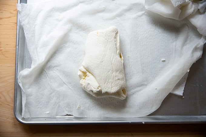 Drained ricotta on a paper-towel-lined sheet pan.