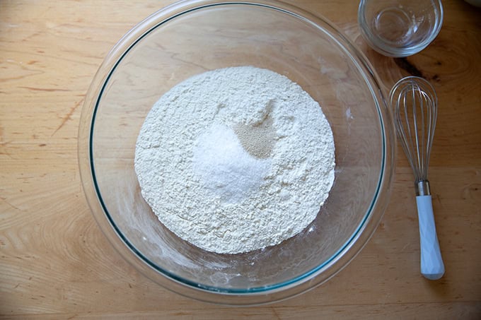 Flour, salt, and yeast in a large glass bowl.
