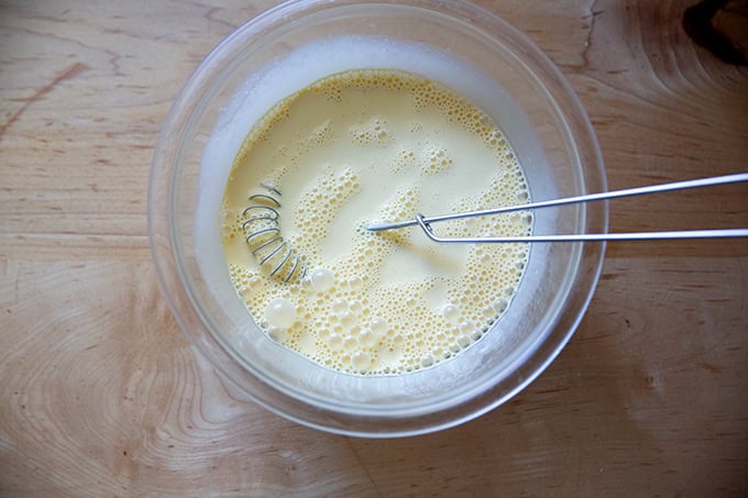 A bowl with heavy cream, vanilla, and eggs whisked together.