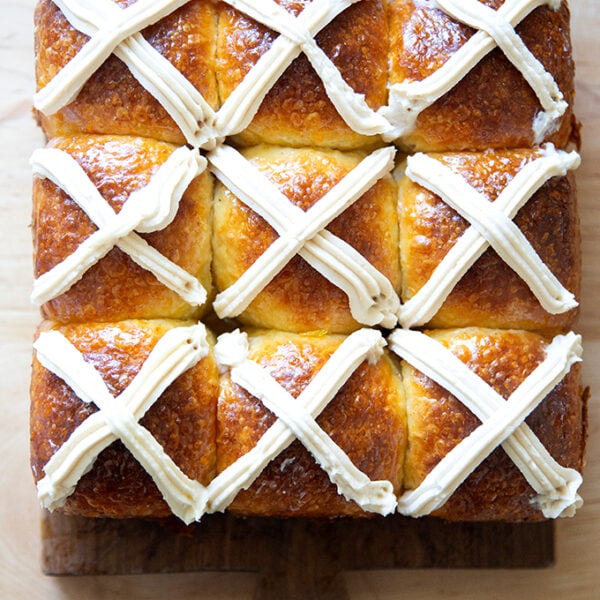 Nine hot cross buns on a serving board.