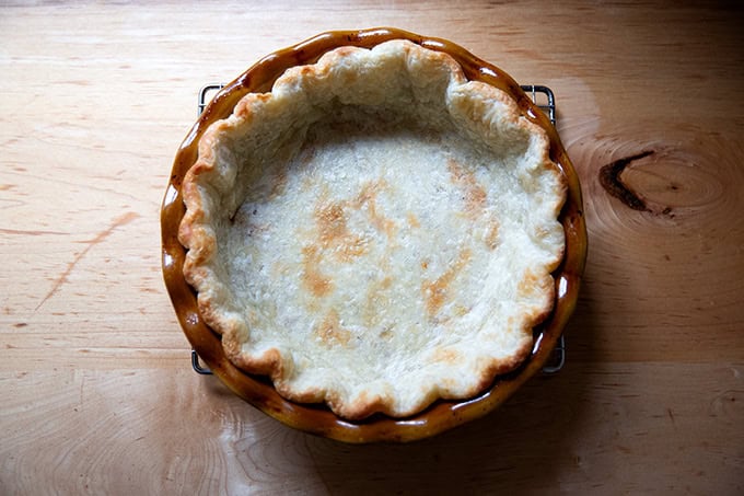A parbaked pie crust on a cooling rack.
