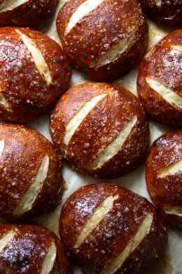Just-baked pretzel rolls on a sheet pan.