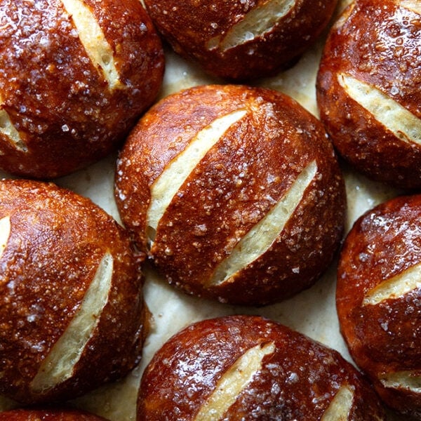 Just-baked pretzel rolls on a sheet pan.