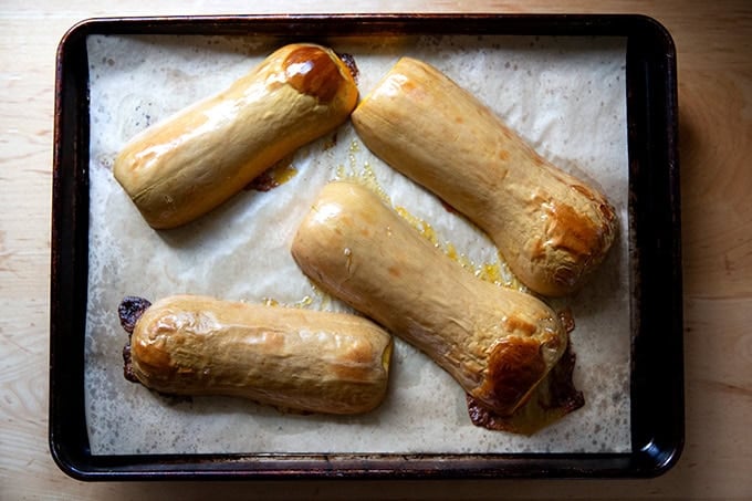 Halved roasted butternut squash on a sheet pan,