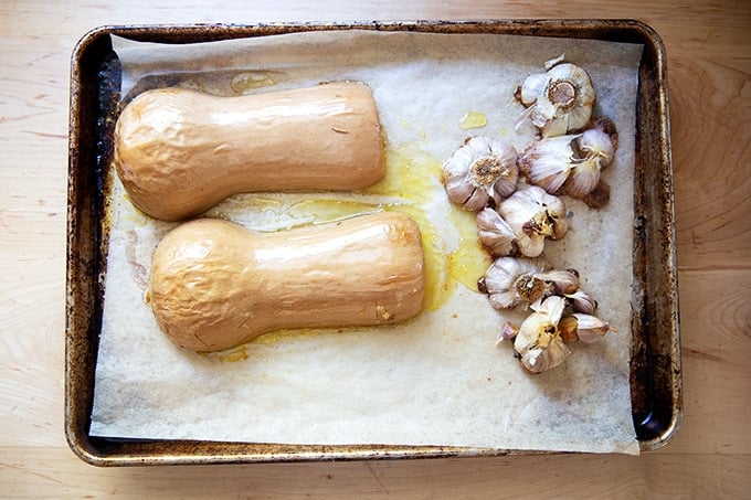 Roasted butternut squash and garlic on a sheet pan.