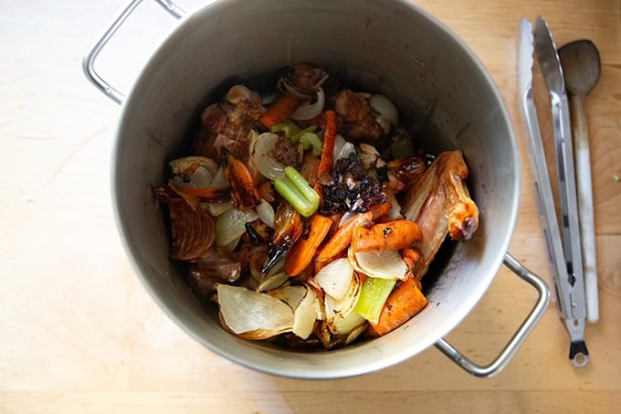 The ingredients — roasted turkey wings and vegetables — to make turkey stock in a large pot.