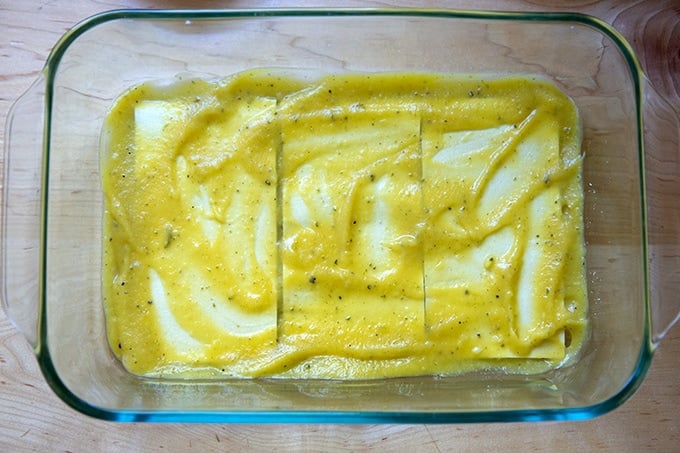 A layer of sauce, noodles, and sauce again in a 9x13-inch baking dish.