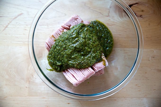 The flavoring sauce for turkey burgers poured over ground turkey in a large glass bowl.