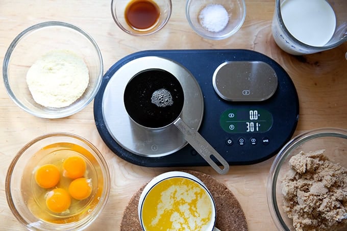 A scale with the ingredients to make salted maple pie all around it.