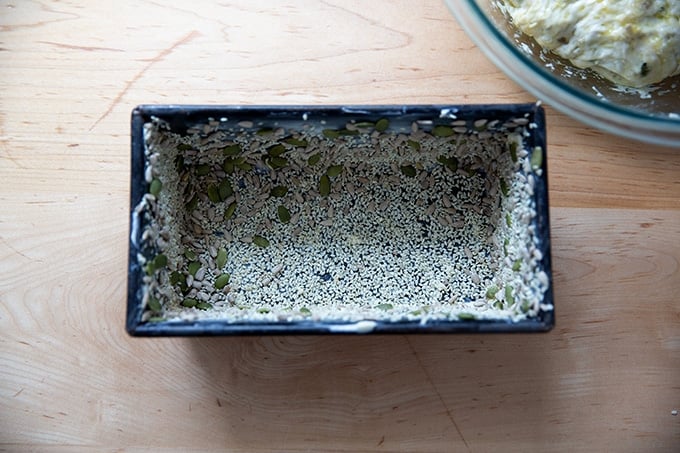 A buttered and seeded loaf pan.