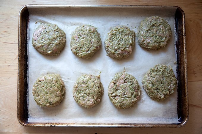 Shaped turkey burgers on a parchment-lined sheet pan.