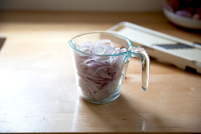 Sliced shallots in a 2-cup measure.
