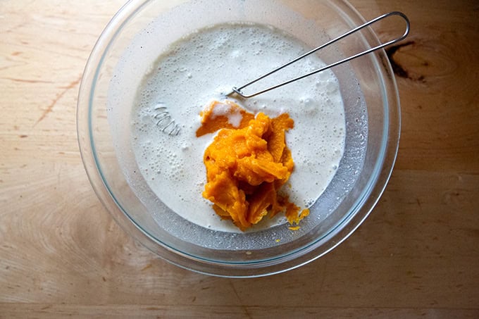 A large bowl filled with the filling ingredients for roasted butternut squash pie.